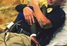 Picture captures a police officer comforting a scared toddler in the hospital